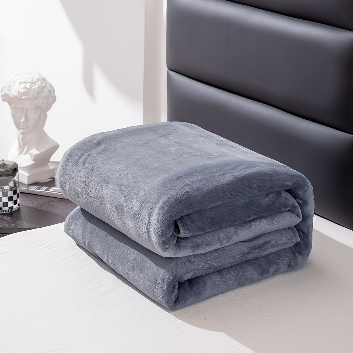 Couverture en flanelle dépliée sur un tapis clair