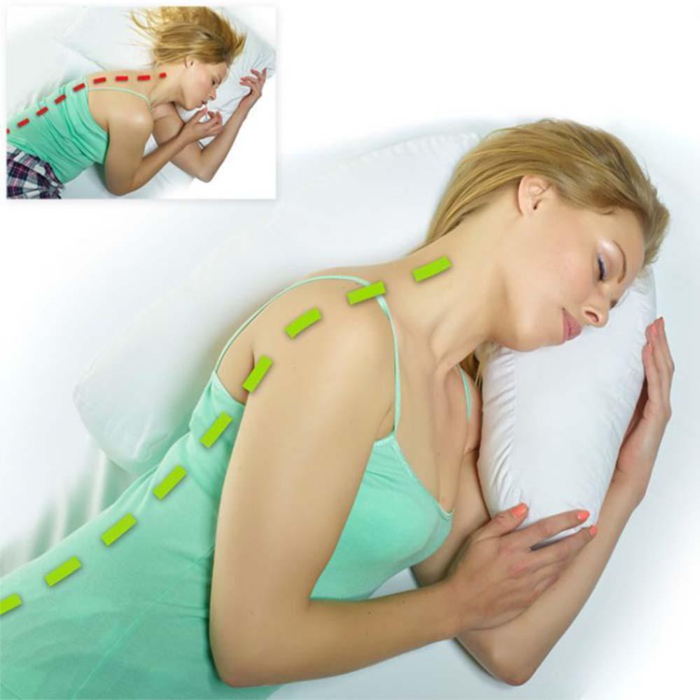 Oreiller ergonomique posé sur un lit, housse en coton blanc