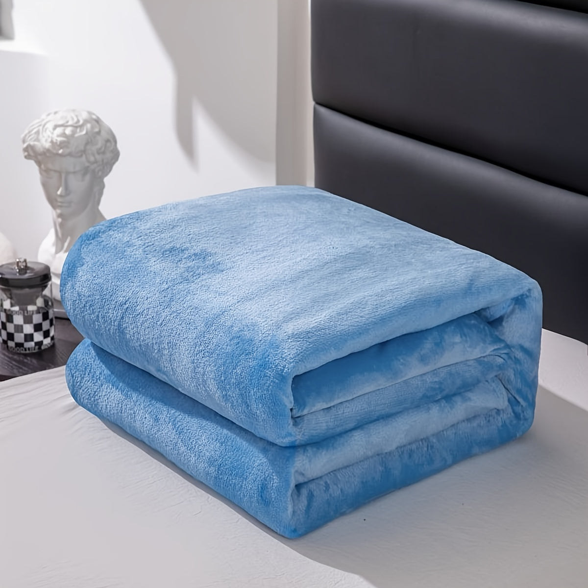 Couverture en flanelle pliée au pied d'un lit