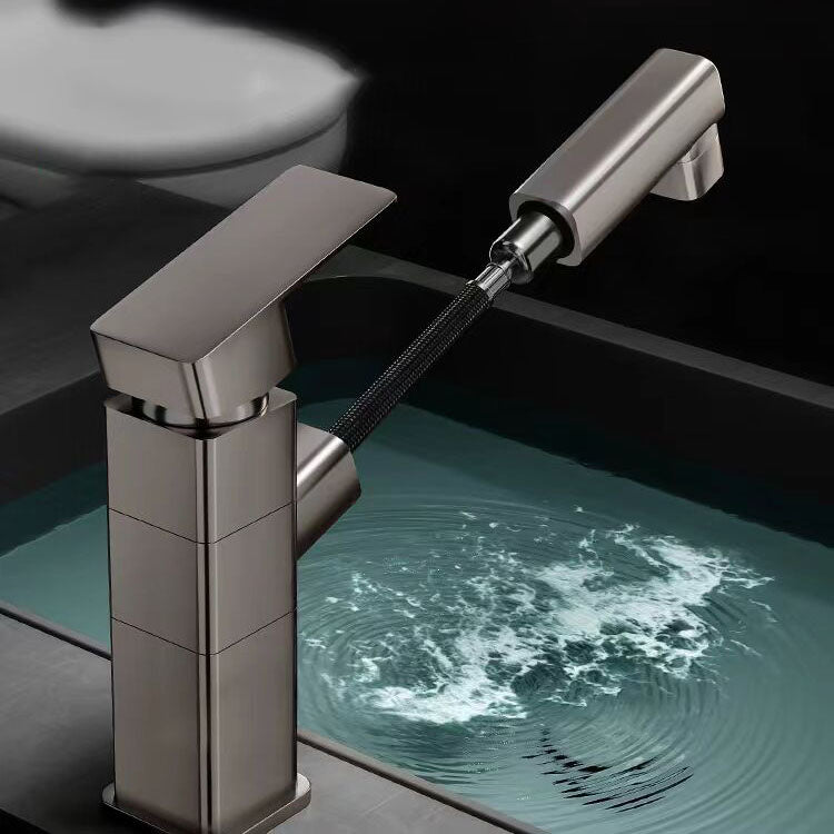 Douchette du robinet de lavabo noir à bec rond pivotant, tenue à la main