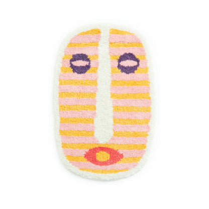 Vue de dessus du tapis de bain et de son motif de visage abstrait