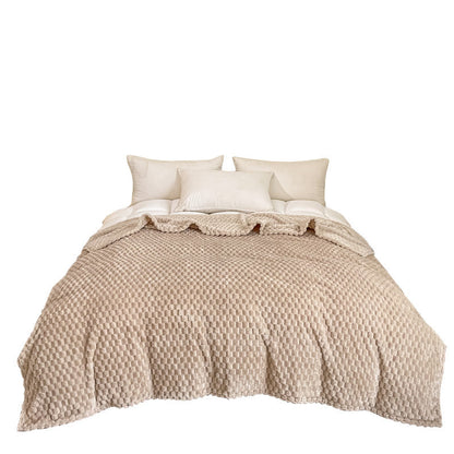 Plaid texturé étalé sur le pied d'un lit