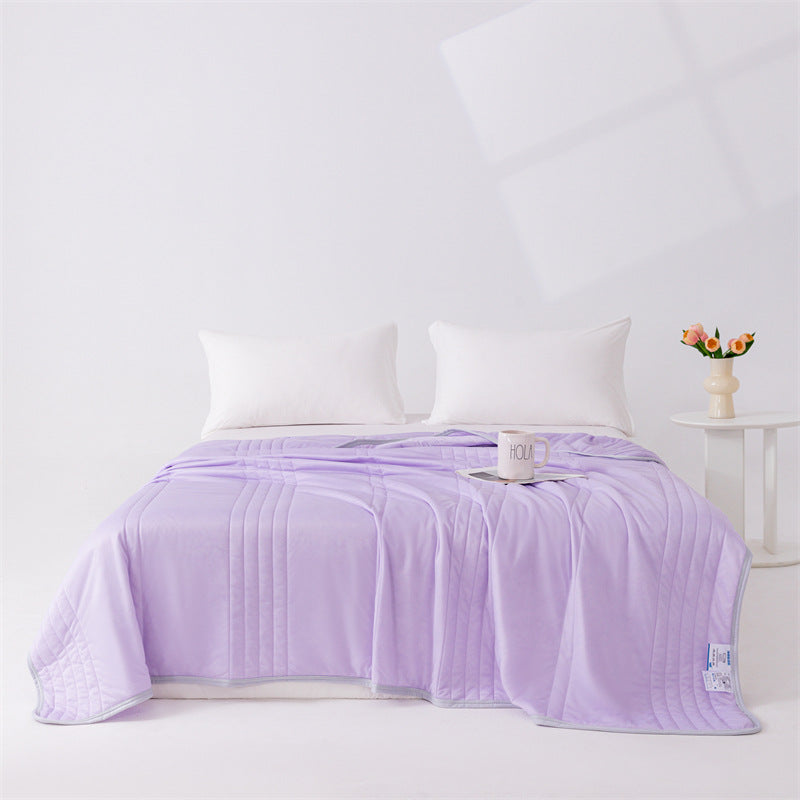Couverture d'été en soie de glace violette posée sur un lit.