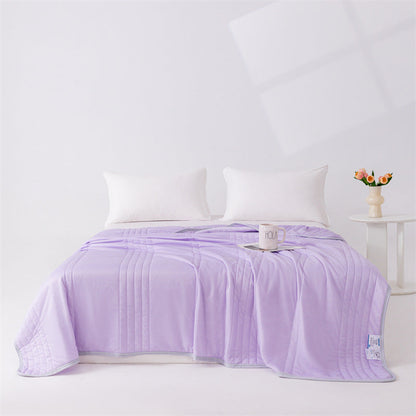 Couverture d'été en soie de glace violette posée sur un lit.