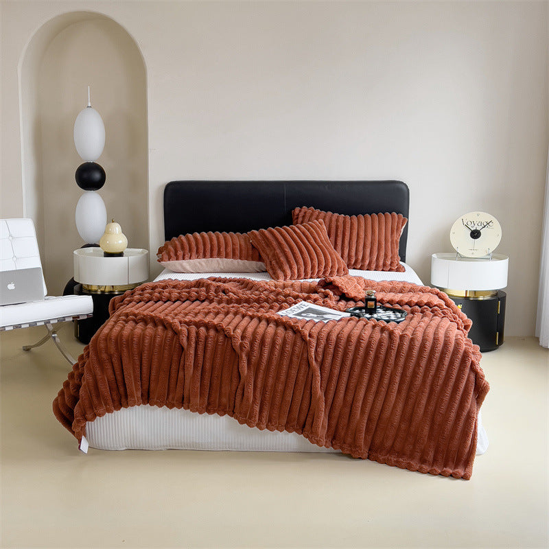 Plaid en peluche blanc déplié sur un lit