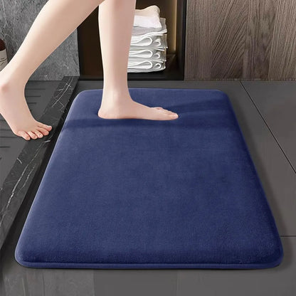 Tapis de bain blanc devant une cabine de douche