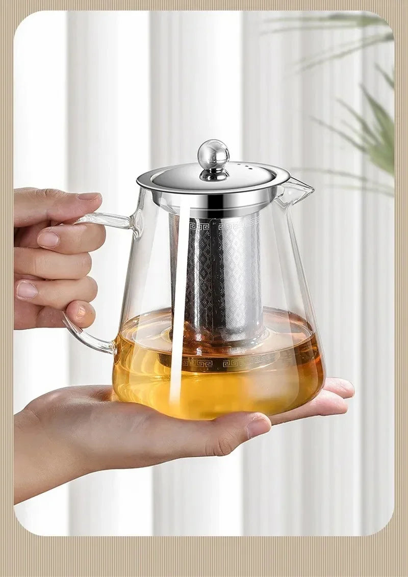 Théière en verre entourée de tasses à thé sur une table en bois