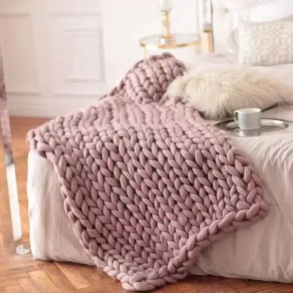 Plaid en grosse maille suspendu sur le dos d'une chaise