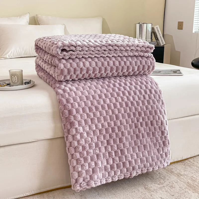 Plaid en velours à carreaux coloris lilas posé sur un canapé
