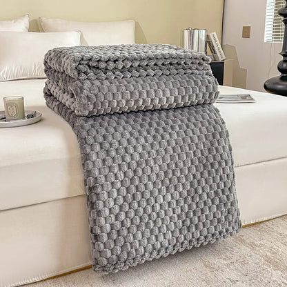 Plaid en velours à carreaux coloris gris posé sur un canapé