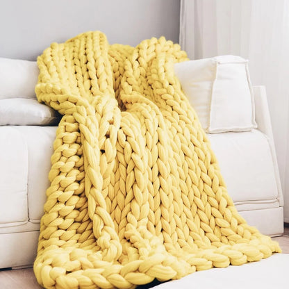 Plaid en grosse maille déployé sur un lit double