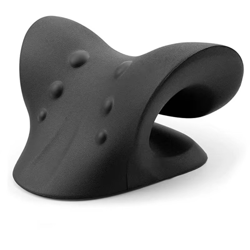 Coussin d'étirement cervical noir posé sur un tapis