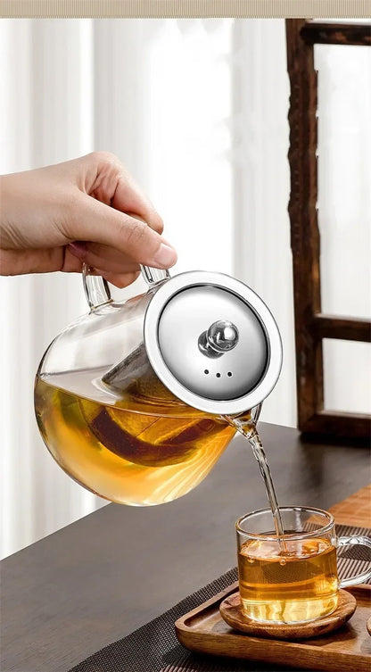 Service du thé depuis la théière en verre vers une petite tasse