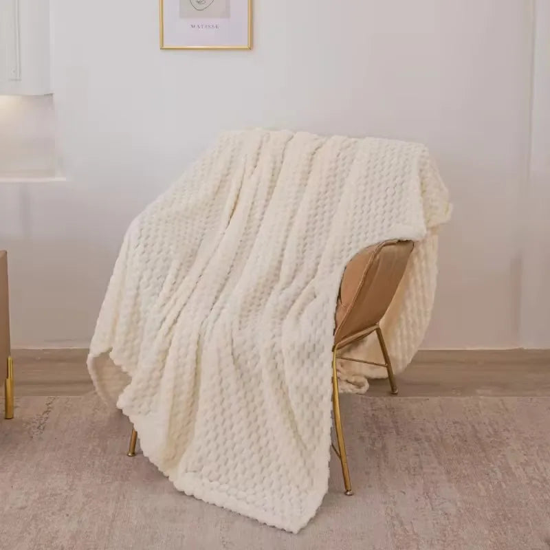 Plaid en velours à motif à carreaux posé sur un canapé