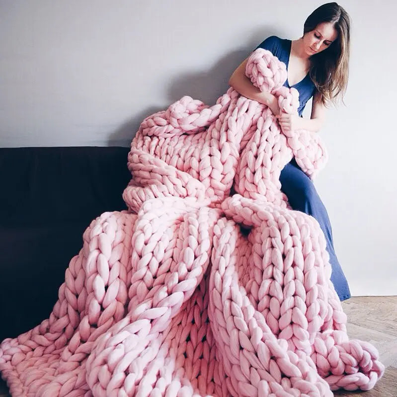 Plaid en grosse maille plié sur l'accoudoir d'un fauteuil