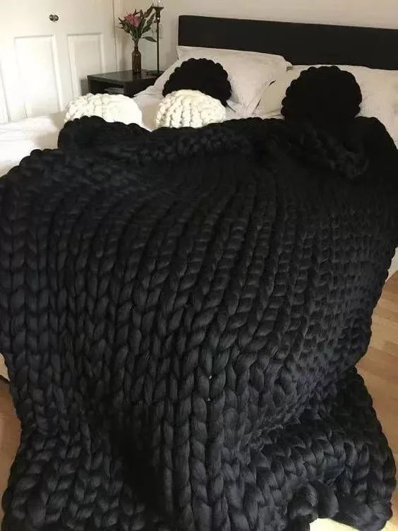 Plaid tricoté sur un canapé avec coussins assortis