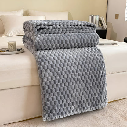Plaid étendu sur un lit comme couche supplémentaire