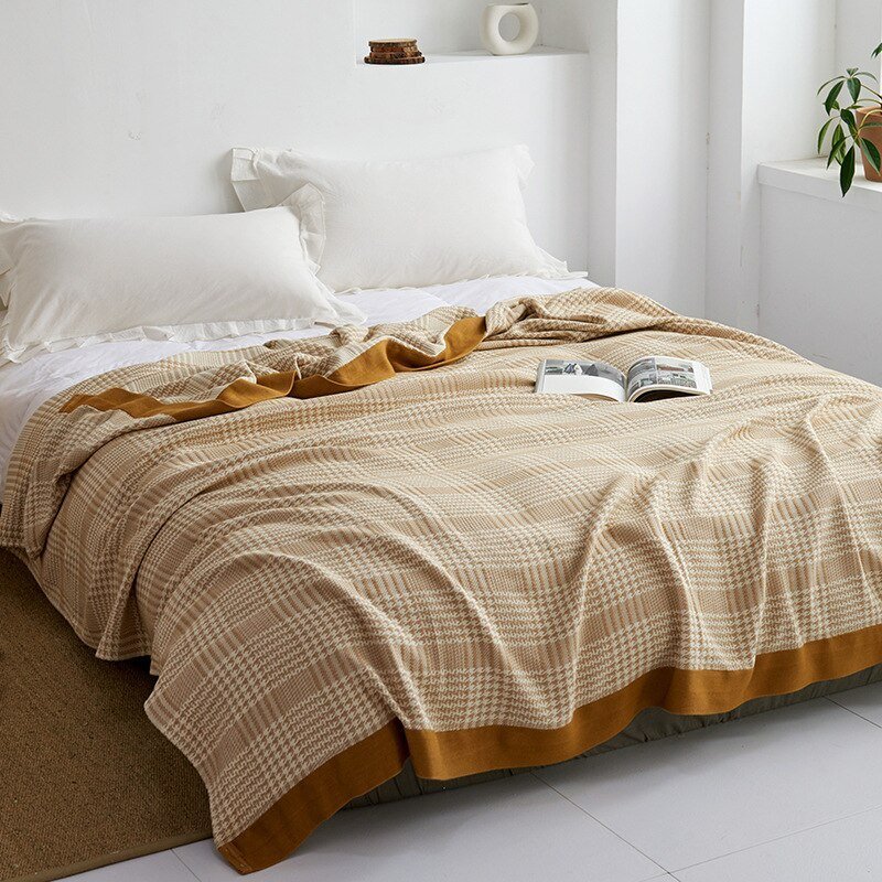 Plaid japonais en coton, motif pied-de-poule doré, posé sur un lit.