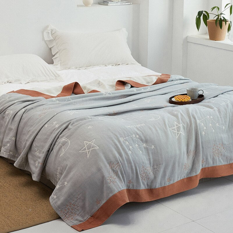 Plaid japonais en coton, motif ciel bleu et marron, posé sur un lit.