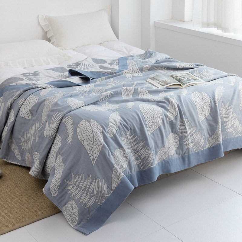 Plaid japonais en coton, motif feuillage bleu, posé sur un lit.