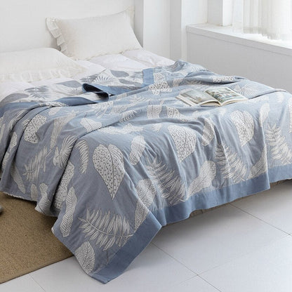 Plaid japonais en coton, motif feuillage bleu, posé sur un lit.