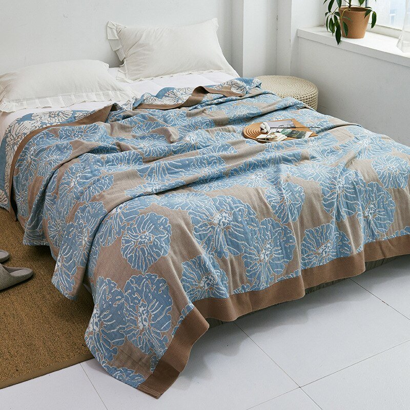 Plaid japonais en coton, motif graphique marron et bleu, posé sur un lit.