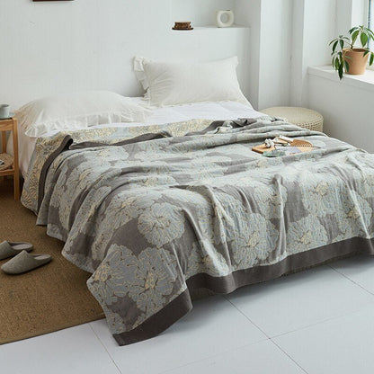 Plaid japonais en coton, motif graphique gris, posé sur un lit.