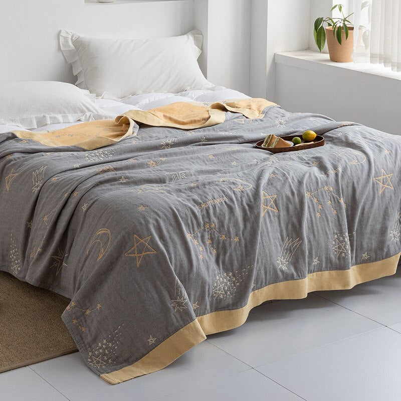 Plaid japonais en coton, motif ciel bleu et doré, posé sur un lit.