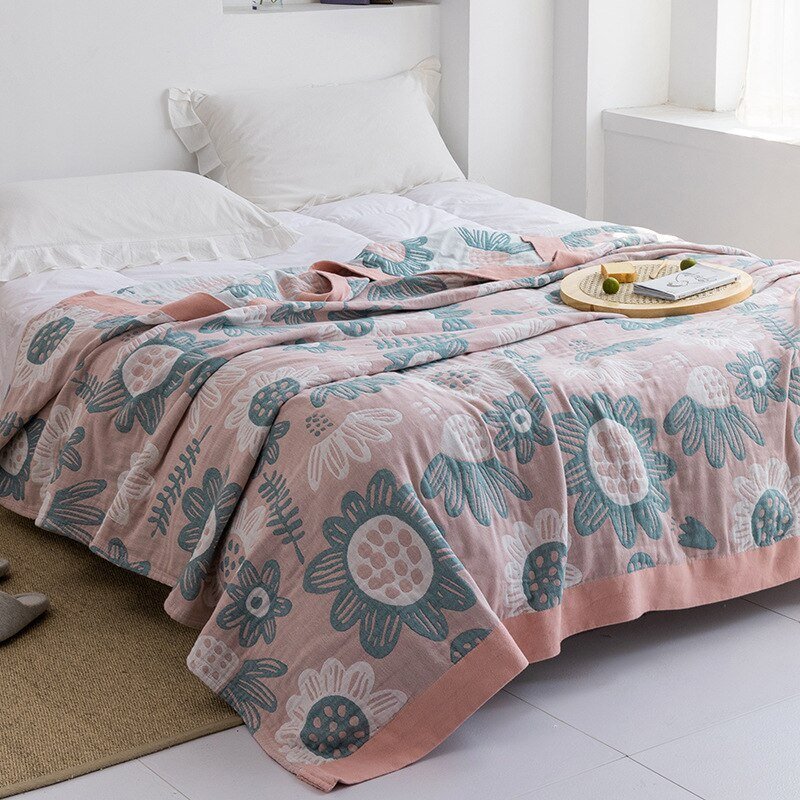 Plaid japonais en coton, motif tournesols rose et bleu, posé sur un lit.