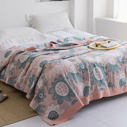 Plaid japonais en coton, motif tournesols rose et bleu, posé sur un lit.