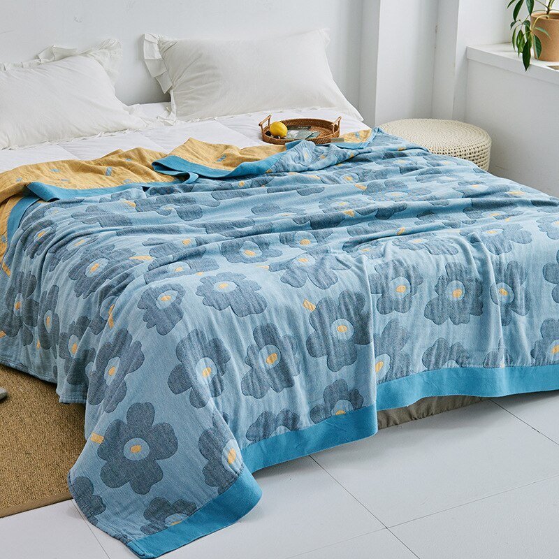 Plaid japonais en coton, motif fleurs bleu, posé sur un lit.