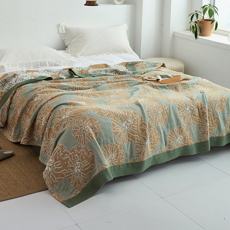 Plaid japonais en coton, motif graphique vert et marron, posé sur un lit.