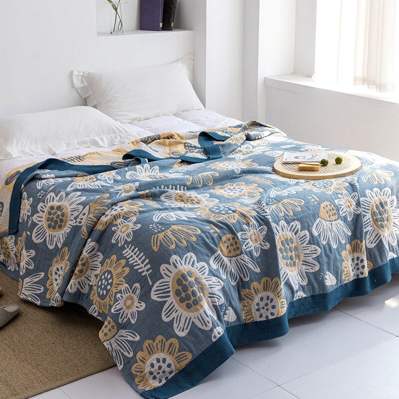 Plaid japonais en coton, motif tournesols bleu et jaune, posé sur un lit.