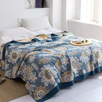 Plaid japonais en coton, motif tournesols bleu et jaune, posé sur un lit.