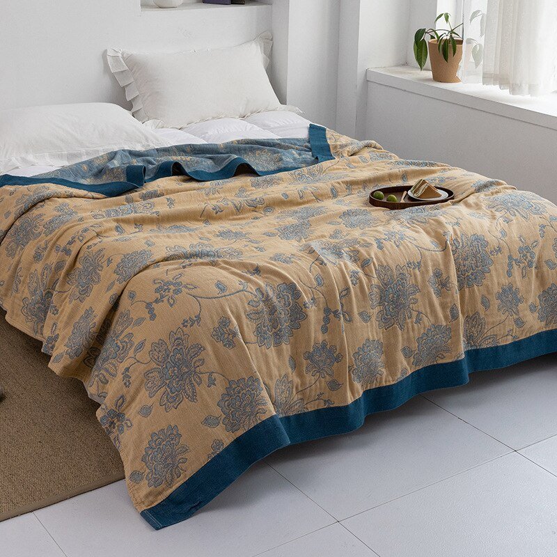 Plaid japonais en coton, motif fleur jaune et bleu, posé sur un lit.