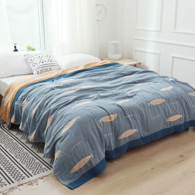 Plaid japonais en coton, motif poissons bleu, posé sur un lit.