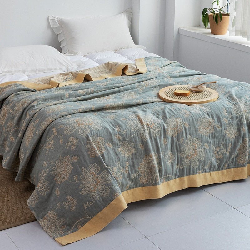 Plaid japonais en coton, motif fleur bleu et doré, posé sur un lit.