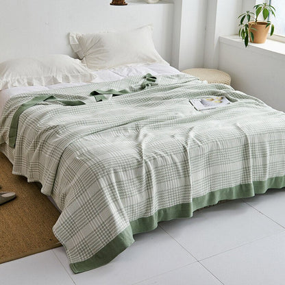 Plaid japonais en coton, motif pied-de-poule vert, posé sur un lit.