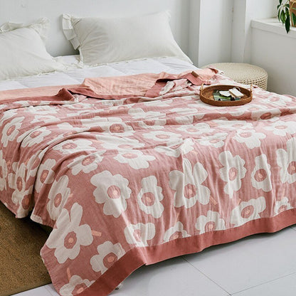 Plaid japonais en coton, motif fleurs rose et blanc, posé sur un lit.
