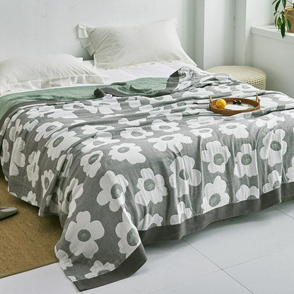 Plaid japonais en coton, motif fleurs vert, posé sur un lit.
