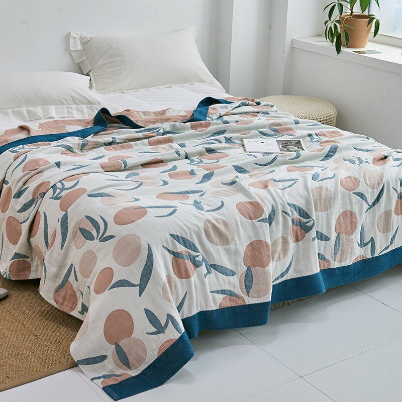 Plaid japonais en coton, motif feuillage blanc et bleu, posé sur un lit.