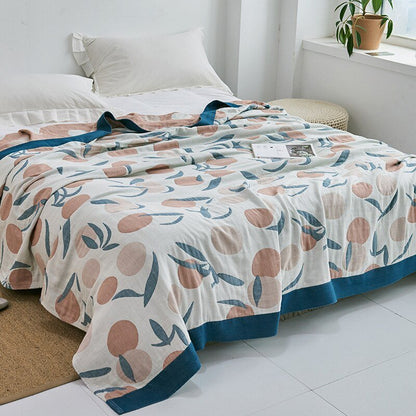 Plaid japonais en coton, motif feuillage blanc et bleu, posé sur un lit.