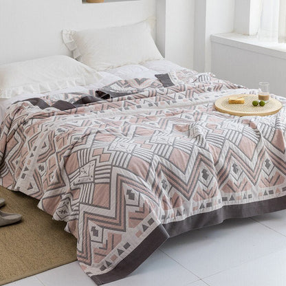 Plaid japonais en coton, motif aztèque rose, posé sur un lit.