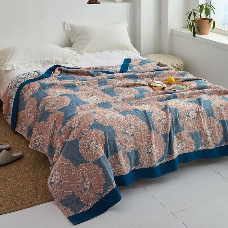 Plaid japonais en coton, motif graphique bleu et rose, posé sur un lit.