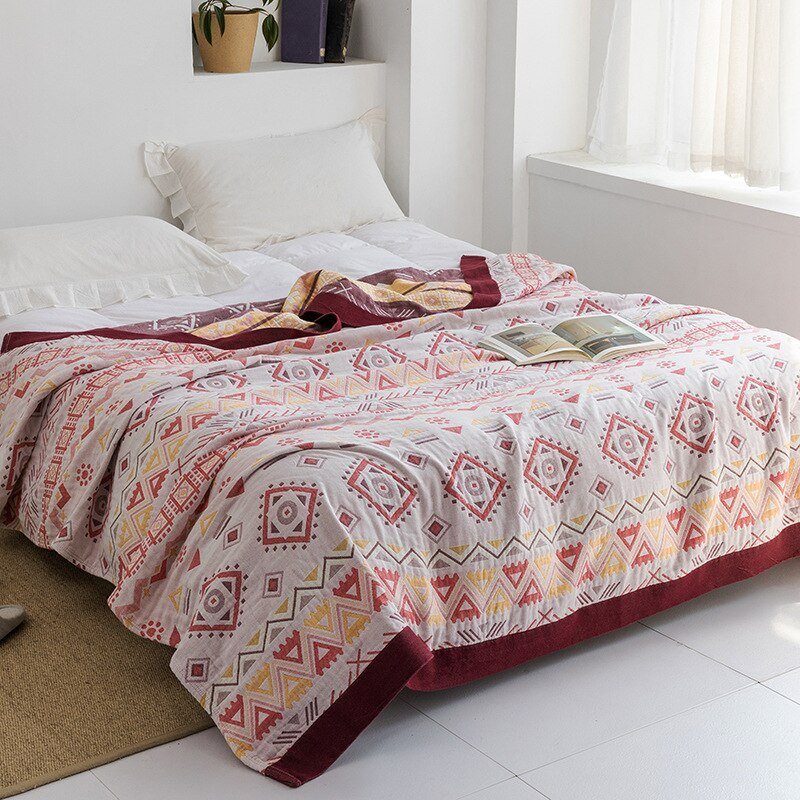 Plaid japonais en coton, motif patchwork blanc et rose, posé sur un lit.