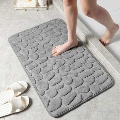 Tapis de bain moelleux posé sur le carrelage d'une salle de bains