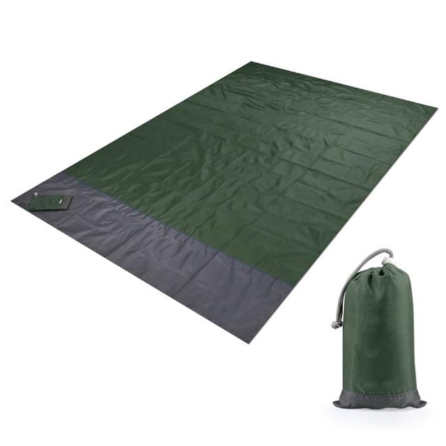 Couverture de plage anti-sable tendue avec ses quatre piquets d'ancrage