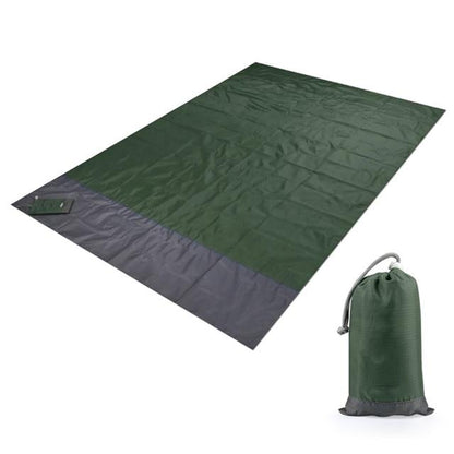 Couverture de plage anti-sable tendue avec ses quatre piquets d'ancrage